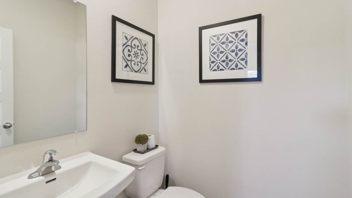Powder bathroom with a pedestal sink and mirror
