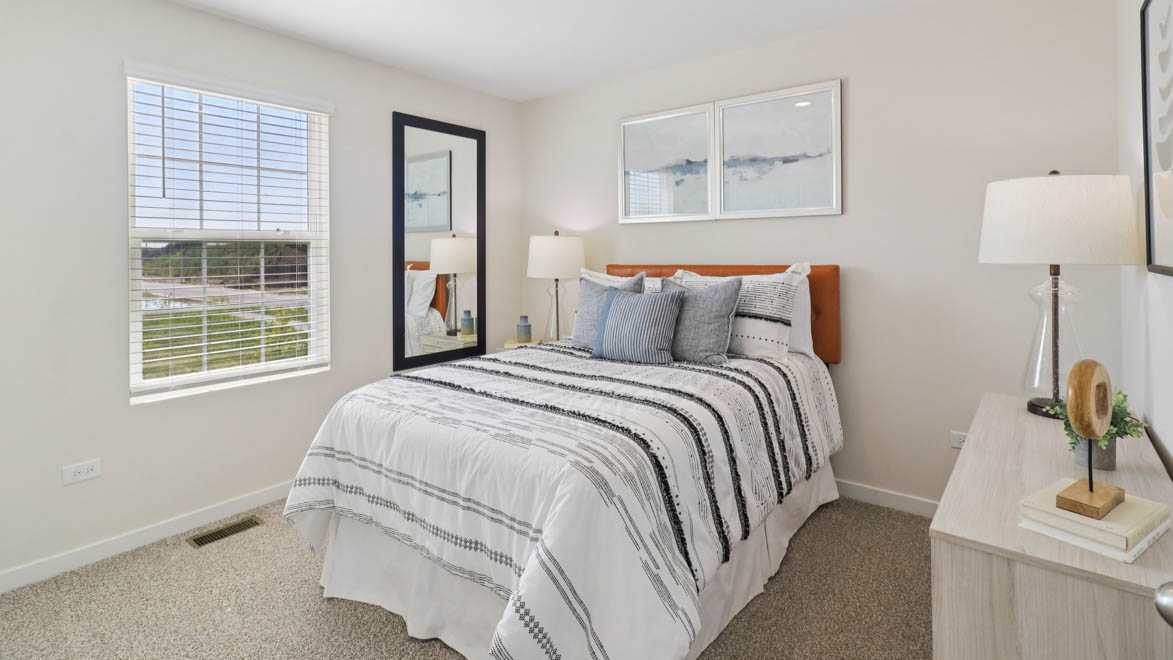 bedroom with beige carpet, white walls and a window