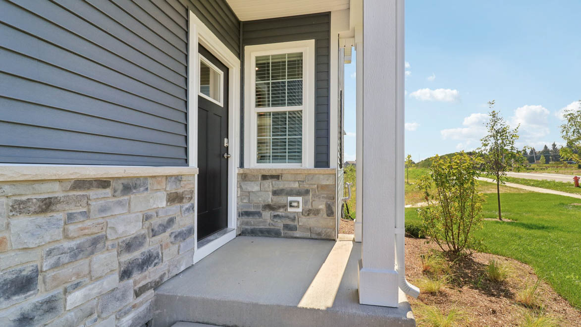 front exterior of a townhome with grey siding and a 2 car gargae