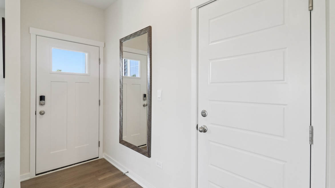 front entry way of home featuring brown flooring and white walls