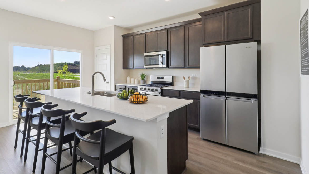 kitchen with brown cabinetry, large island and stainless steel appliances