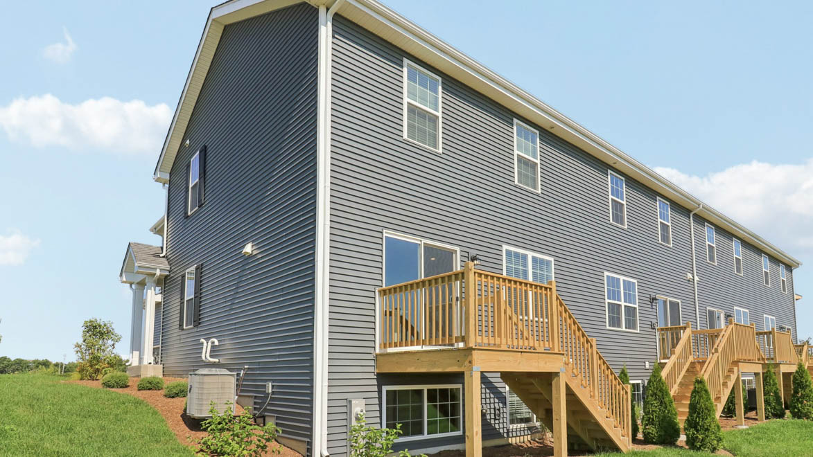 rear exterior of home featuring a spacious backyard