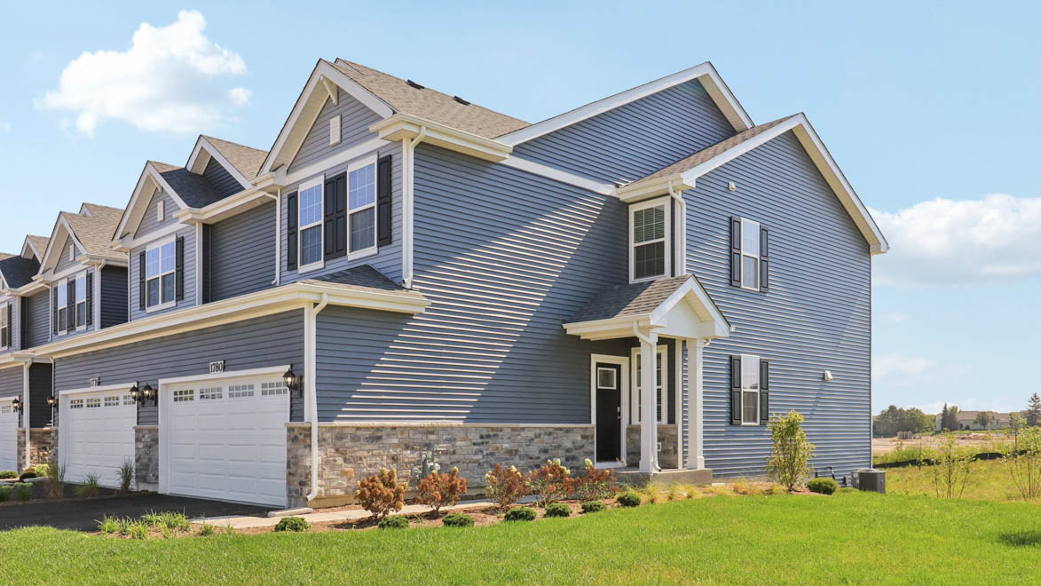 Ashton townhome end unit with blue vinyl siding and stone accent