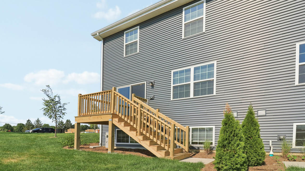 Back of home with lookout basement and deck