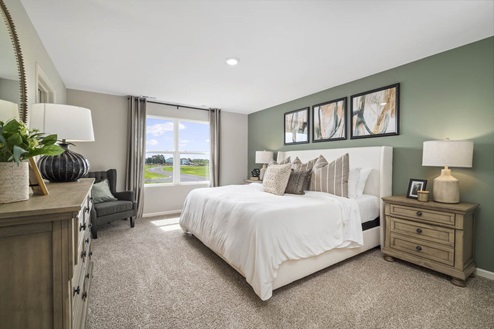 Spacious primary room with king bed in Ivanhoe Holcombe model