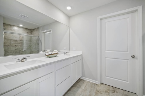 Primary bathroom with shower and double bowl vanities in Ivanhoe Holcombe model