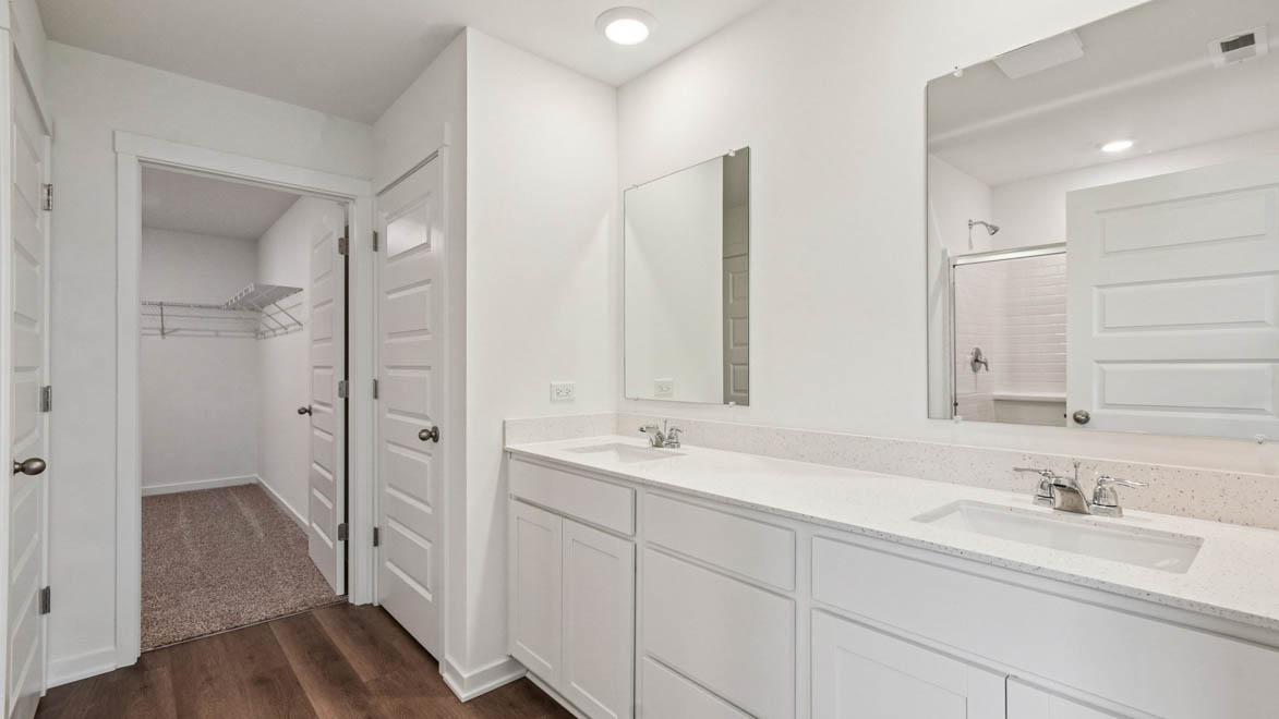 Primary bathroom with dual sinks and linen closet
