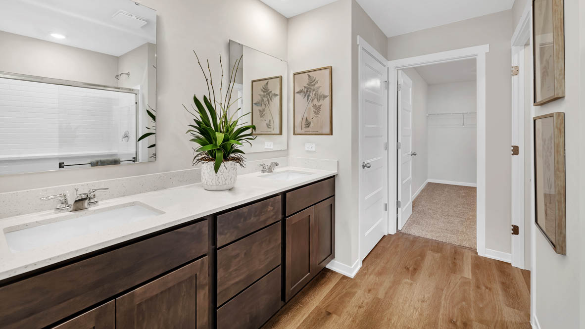 Primary bathroom with dual sinks and walk in closet