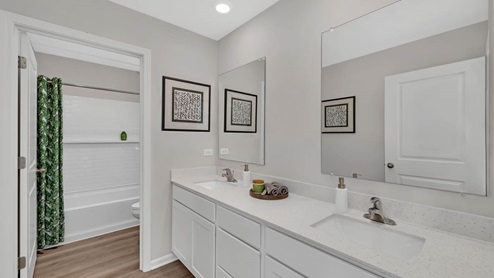 Full bathroom with dual vanity sink and water closet