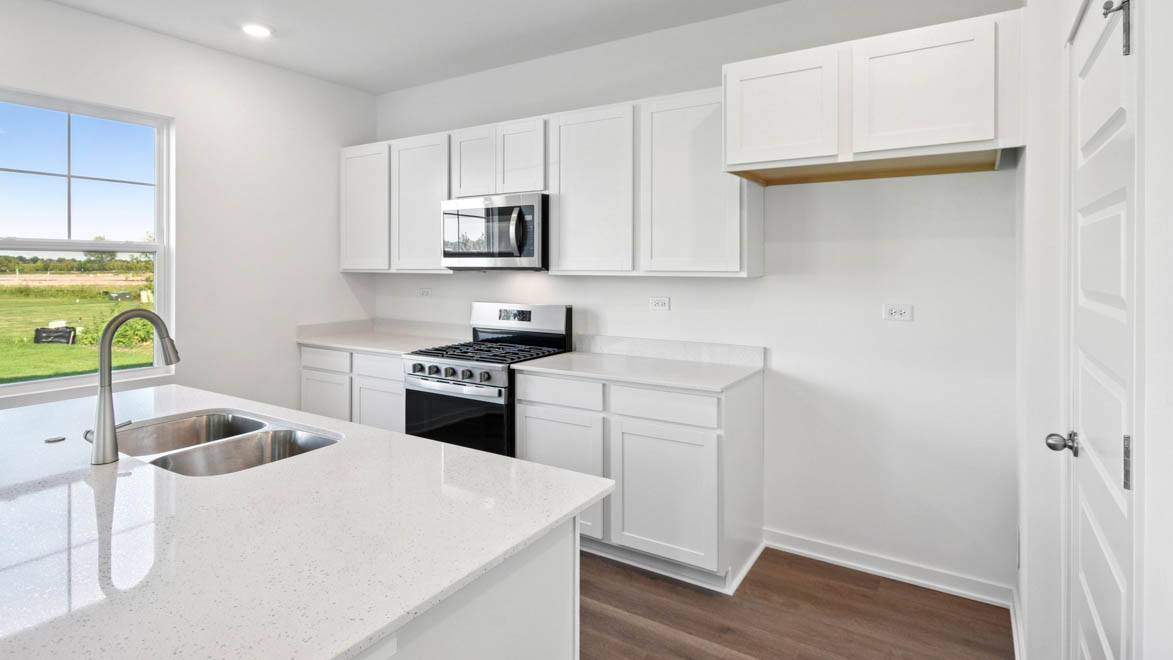 Kitchen with white quartz countertops and white cabinetry