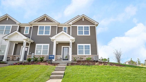 Two story Norfolk townhome model with vinyl siding and stone accent