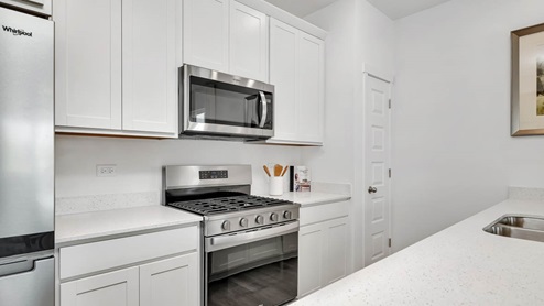 Kitchen with white 42 inch cabinets and white quartz countertops