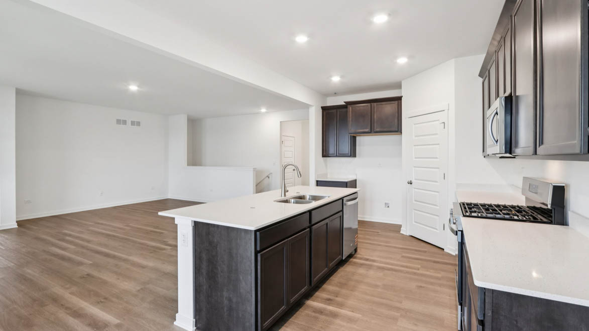 kitchen with lower and upper dark cabinets and white quartz countertops