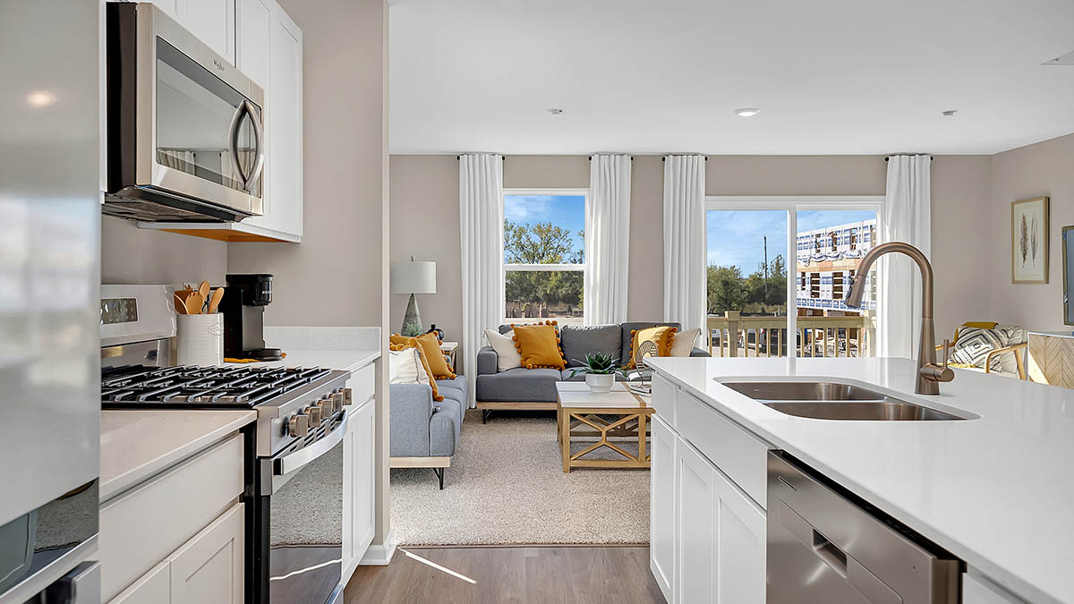 Open concept kitchen with white cabinets and stainless steel aplliances
