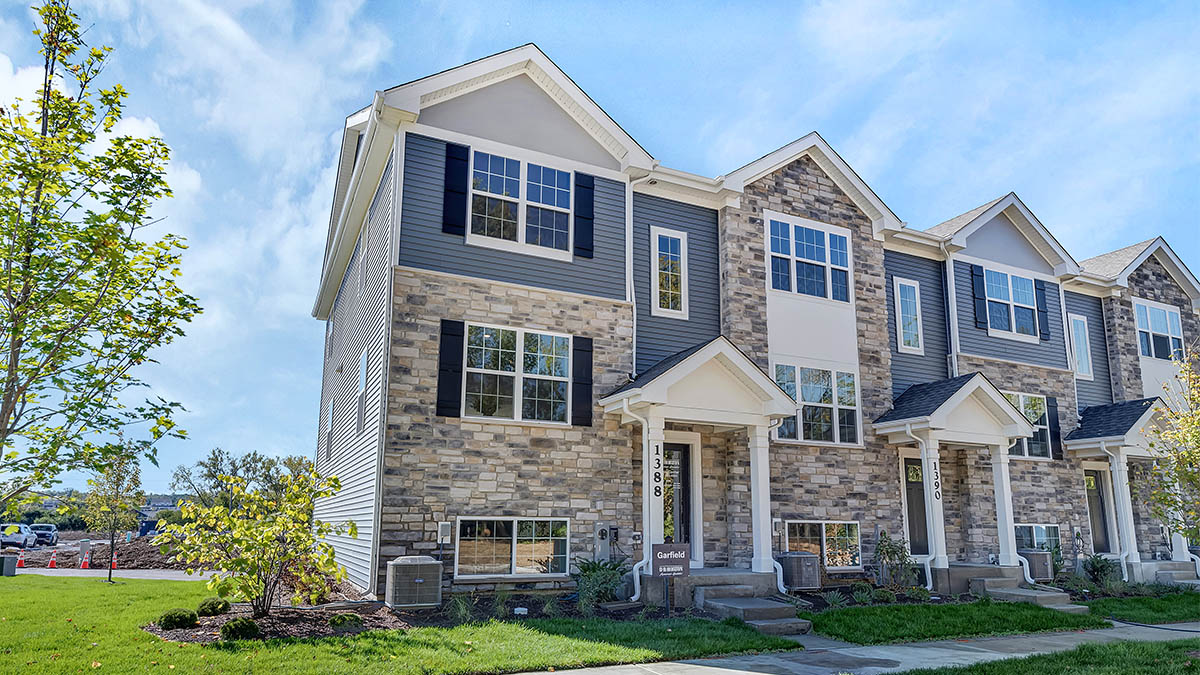 3-story townhomes building with blue siding and stone accents