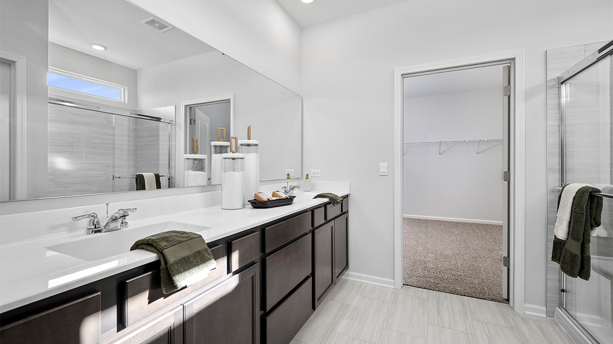 Primary bathroom with dual sinks and walk in closet
