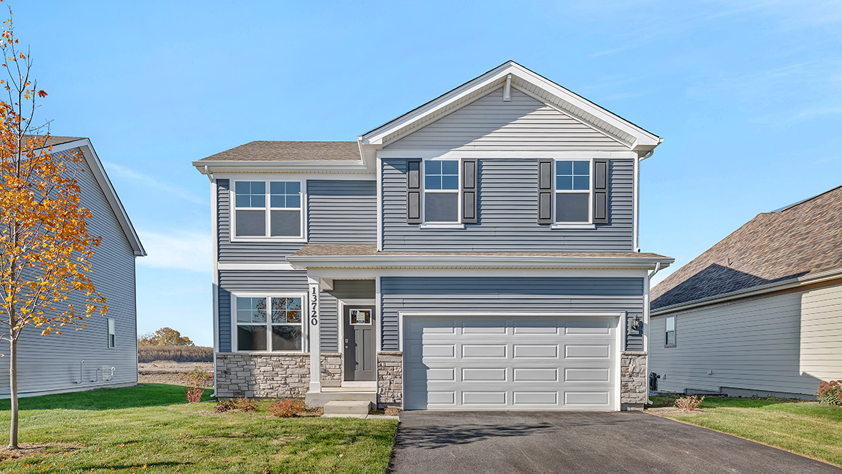front exterior of home with blue vinyl siding and stone accents