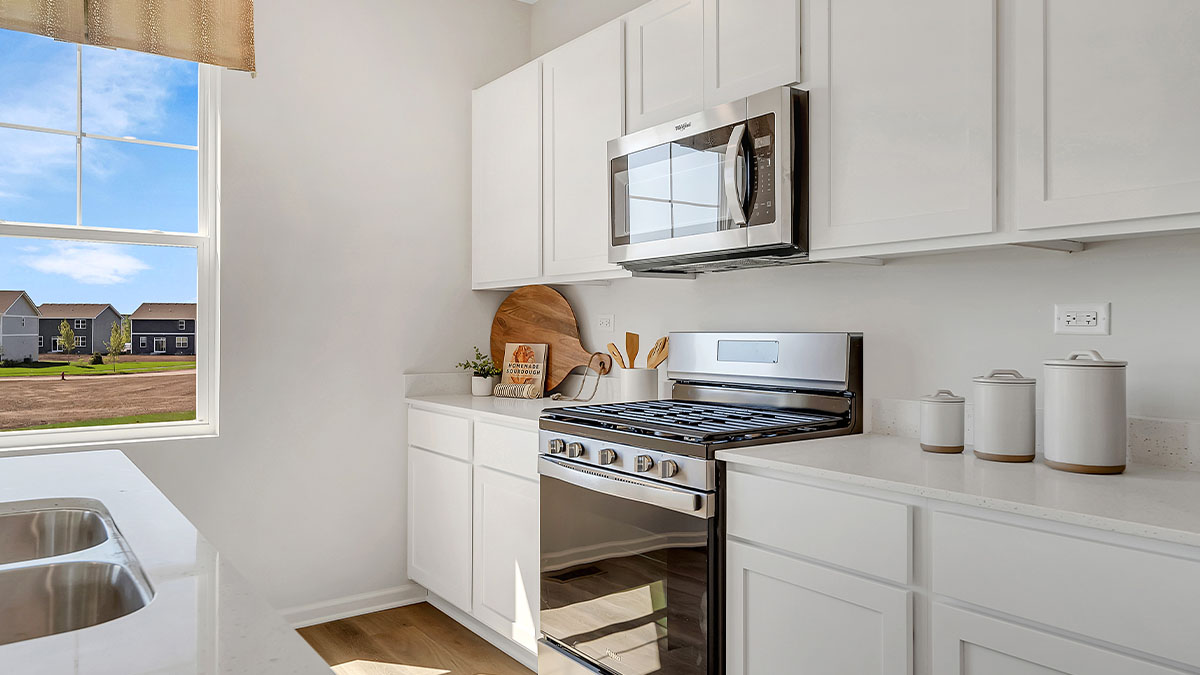 Kitchen with white quartz countertops and white cabinetry