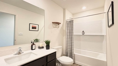 secondary full bathroom with stainleel steel appliances