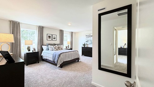 Primary suite with plush carpeting and an attached full bathroom
