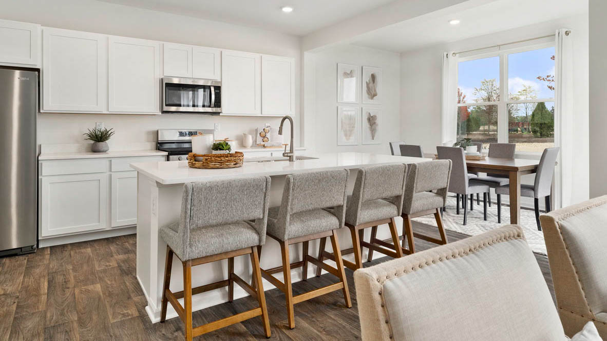 Large kitchen with white cabinets and white quartz countertops