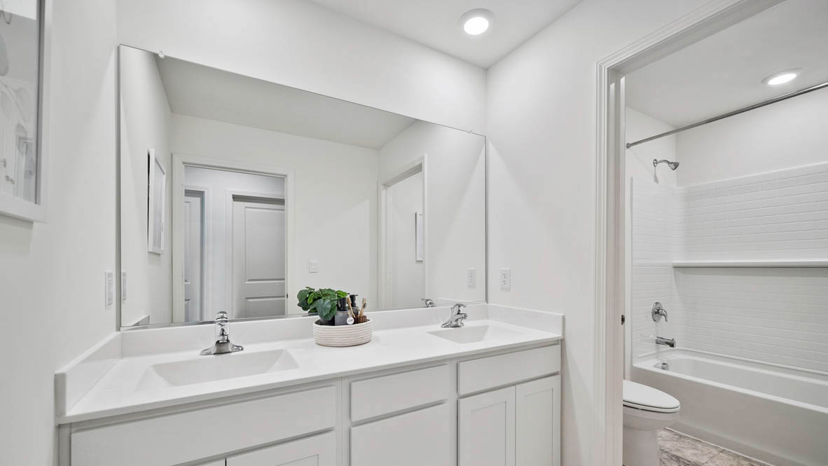 secondary bathroom with dual sinks and water closet