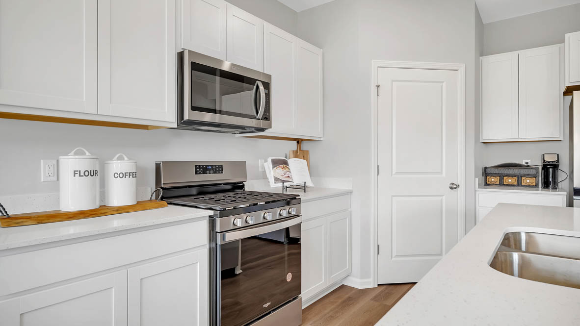 Kitchen with white quartz countertops and white cabinetry