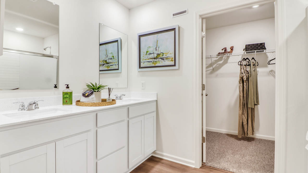 Primary bathroom with dual sinks and walk in closet