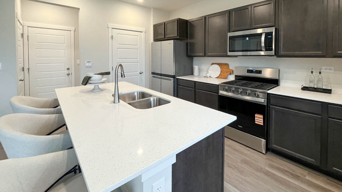 Kitchen with dark cabinets and white quartz countertops