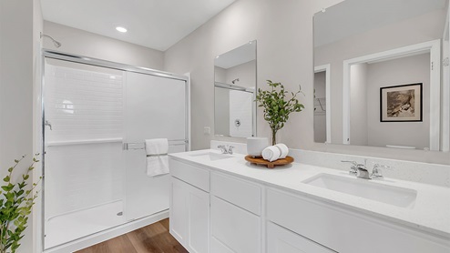 Primary bathroom with walk in shower and dual vanity sink