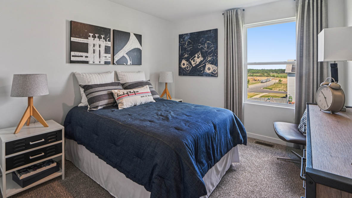 secondary bedroom with carpeted flooring and window