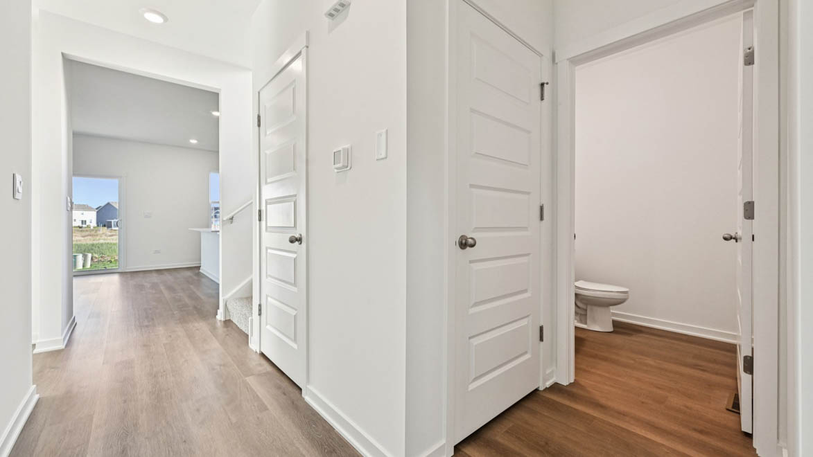 Hallway with coat closet and powder room