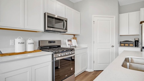 Kitchen with white cabinets and white quartz countertops