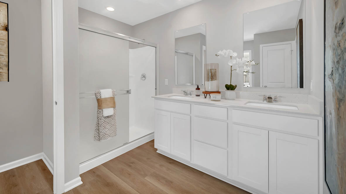 Primary bathroom with dual sinks and walk in closet