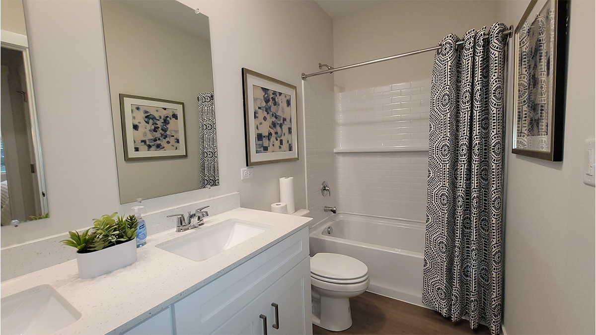 full bathroom with white cabinets