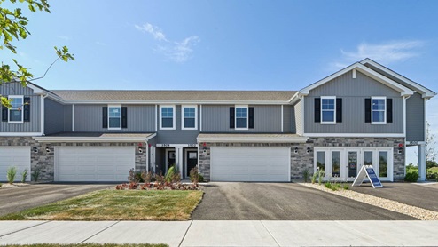Exterior image of the townhomes at grande reserve with grey siding and stone wrap