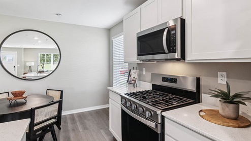 Upper and lower white kitchen cabinets with white quartz countertops