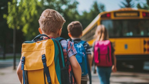 stock photo of kids walking to a school bus
