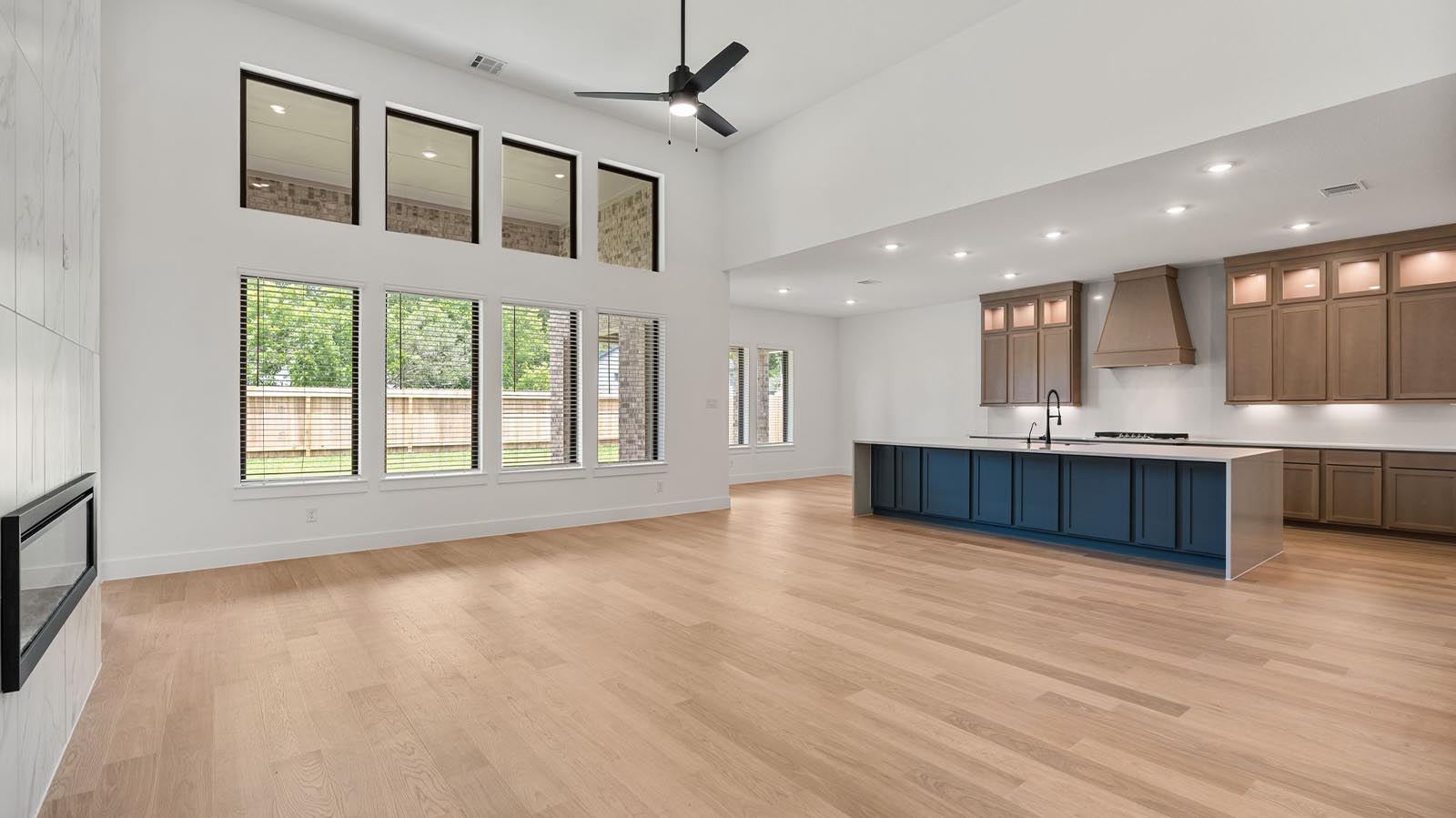 Kitchen and living area with large windows towards the back of the home with natural lighting illuminating the space