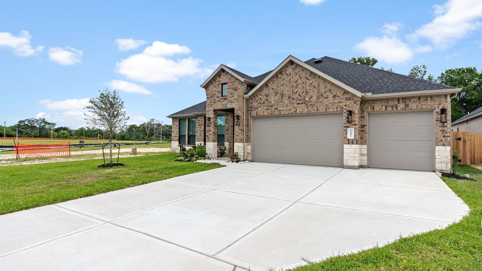 A spacious one-story home with modern interior architecture, a covered patio, four bedrooms, three and a half bathrooms and a three-car garage