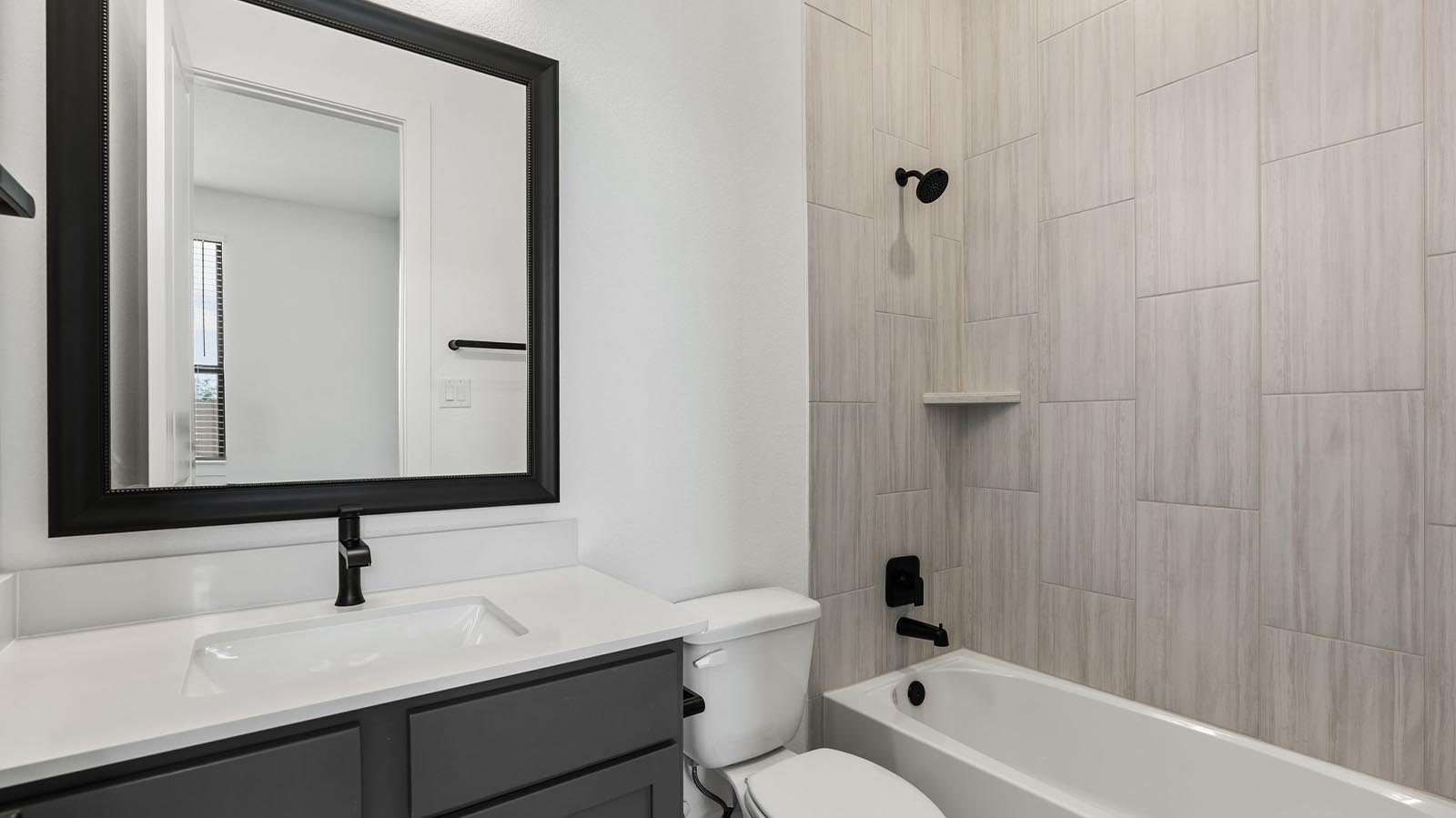 A secondary bathroom with a standing tub, one sink vanity, and a window for natural lighting