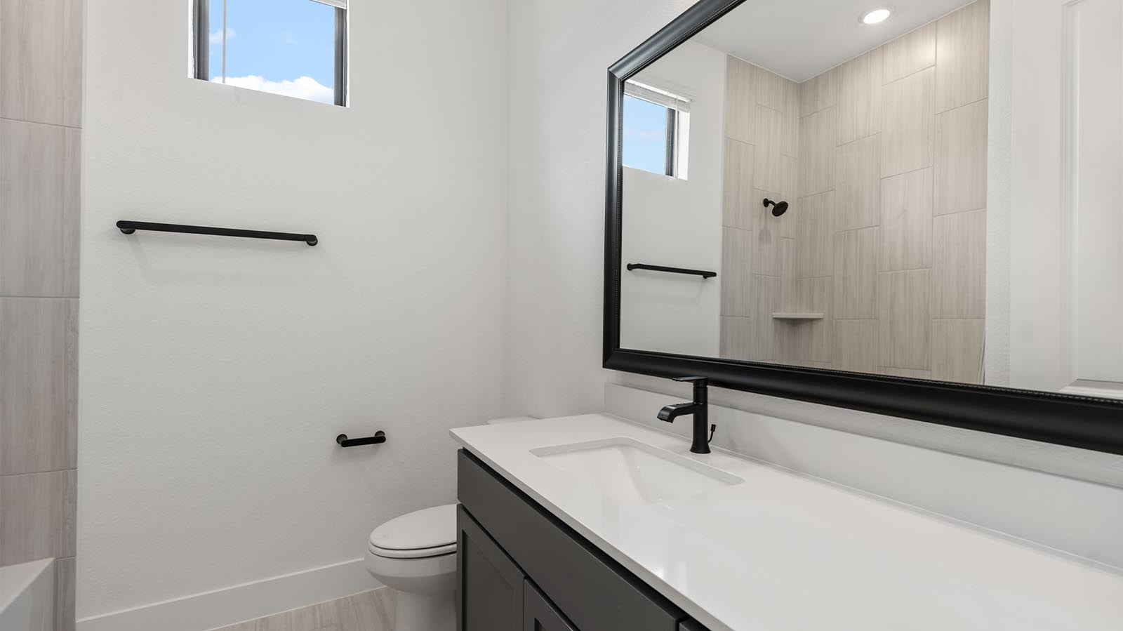 A secondary bathroom with a standing tub, one sink vanity, and a window for natural lighting