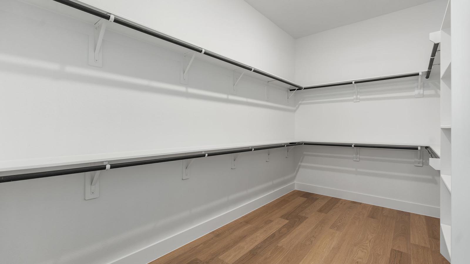 The primary walk-in closet with two rows of shelves and rods for maximum storage opportunities