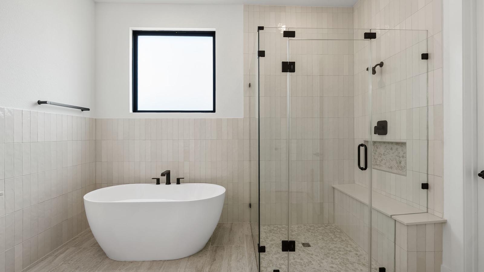 Primary bathroom with a glass-enclosed standing shower and separate soaking tub.