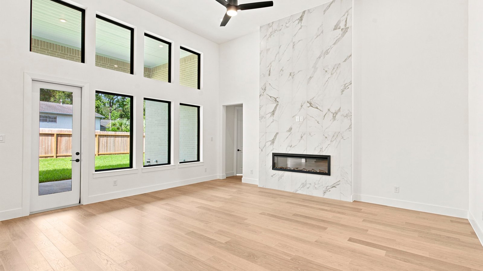 open concept living room with tall ceilings and multiple windows