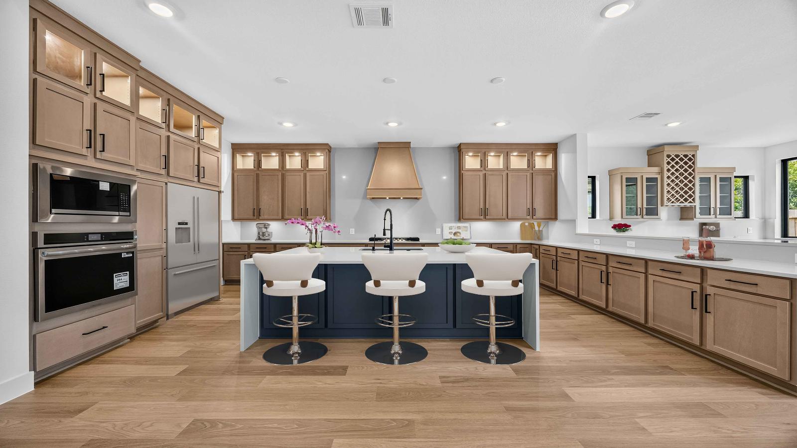 Kitchen and living area with large windows towards the back of the home with natural lighting illuminating the space