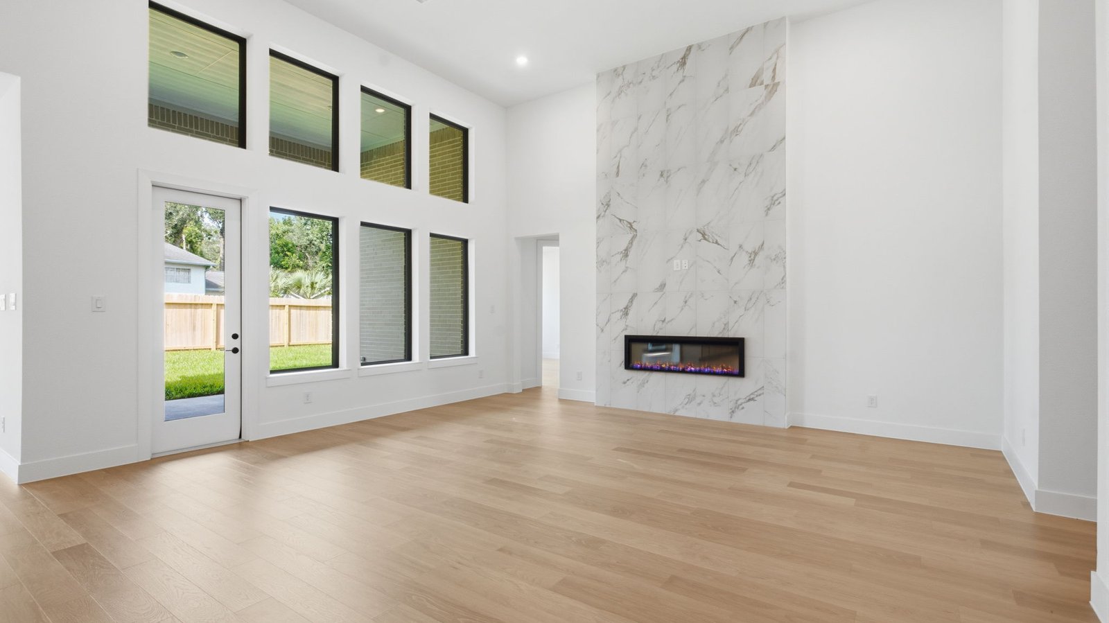 open concept living room with tall ceilings, multiple windows, and fire place