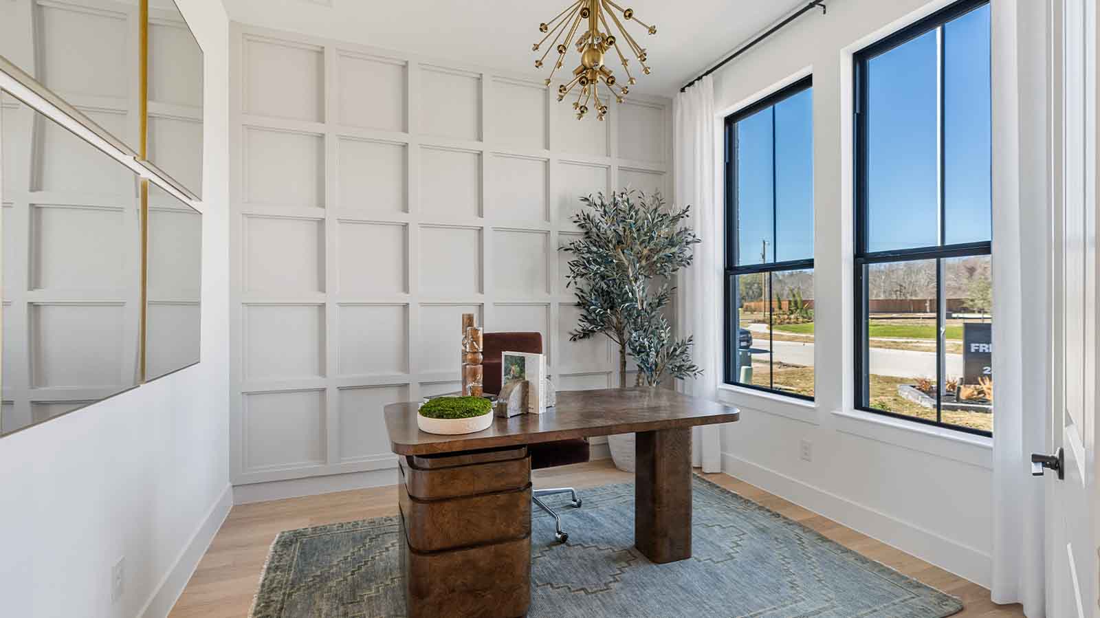 A tidy office featuring a desk, chair, and a window, creating a bright and organized workspace.