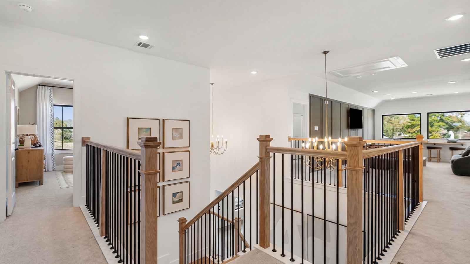 A staircase leading to the second floor with a luminating chandelier