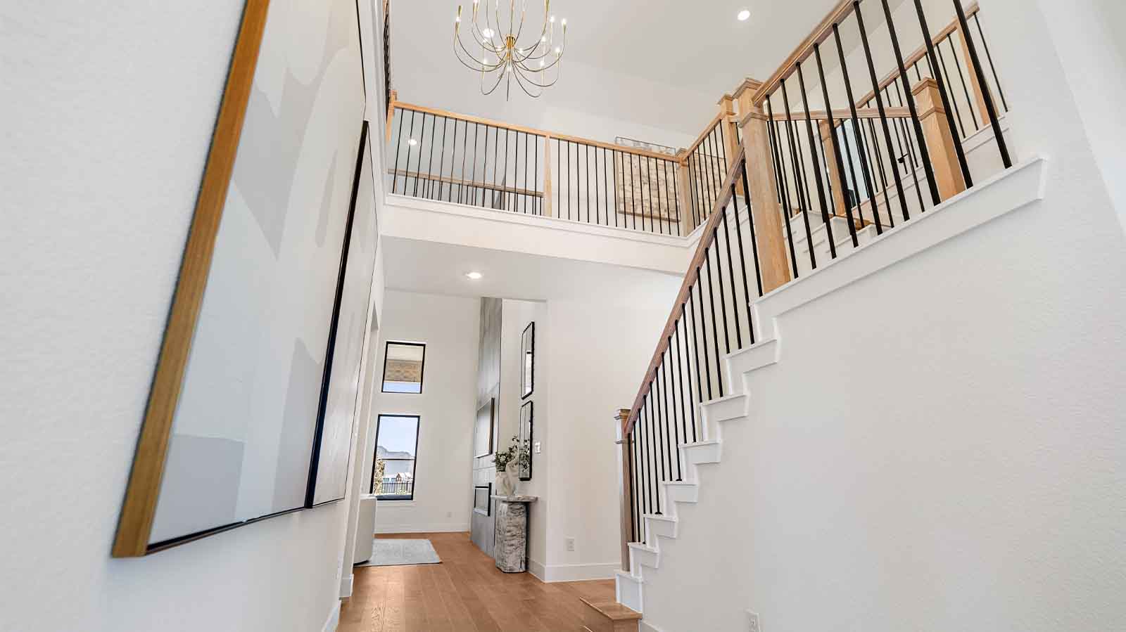 A grand staircase leading to the second floor with a luminating chandelier